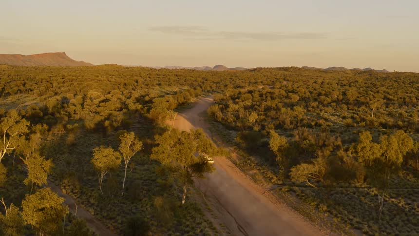 A truck travels on a dirt road in a remote area
