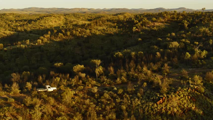 A truck is driving in a wooded area