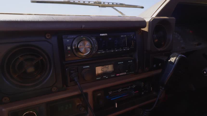 A person puts the cb radio microphone on the dash
