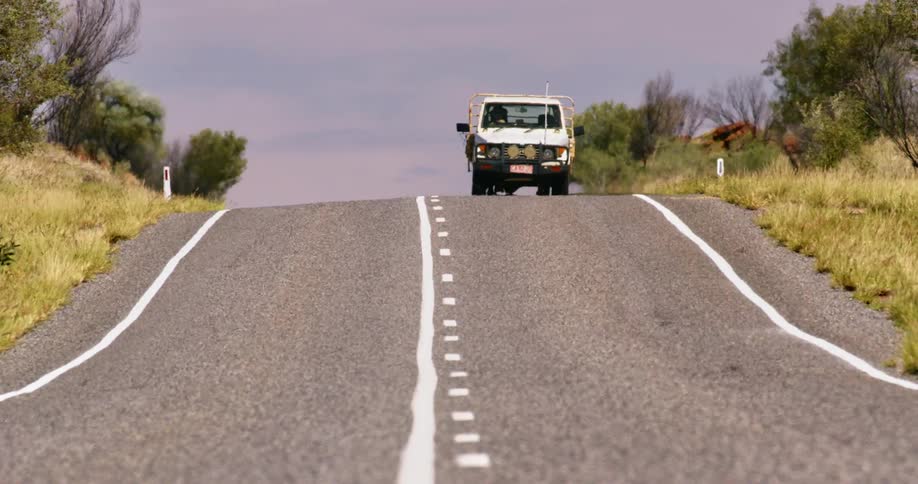 A man drives a truck down a road