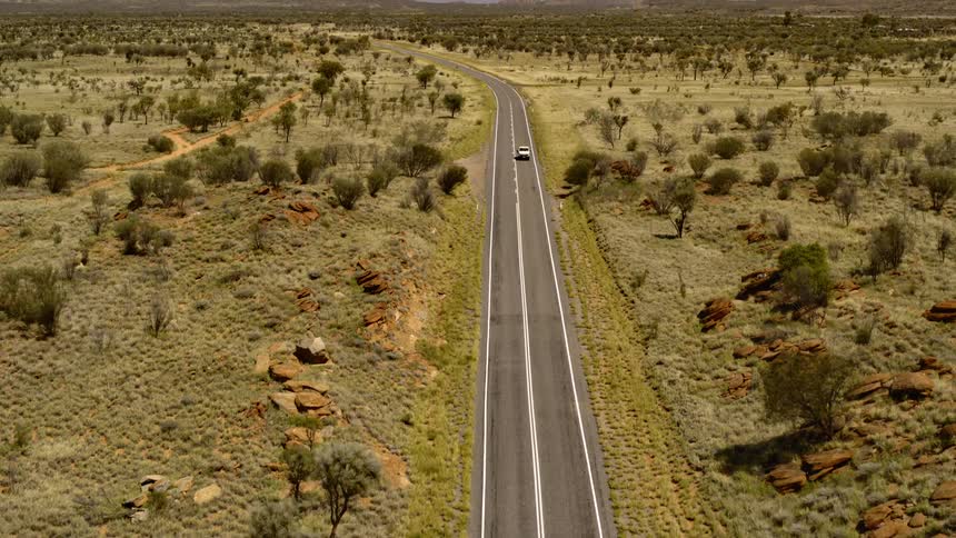 A car drives down the long highway