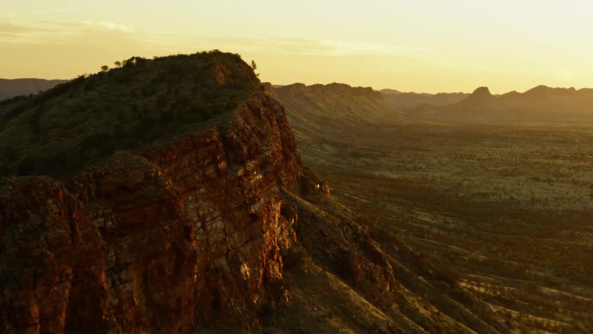 Aerial view of mountain range next to a desert at sunset