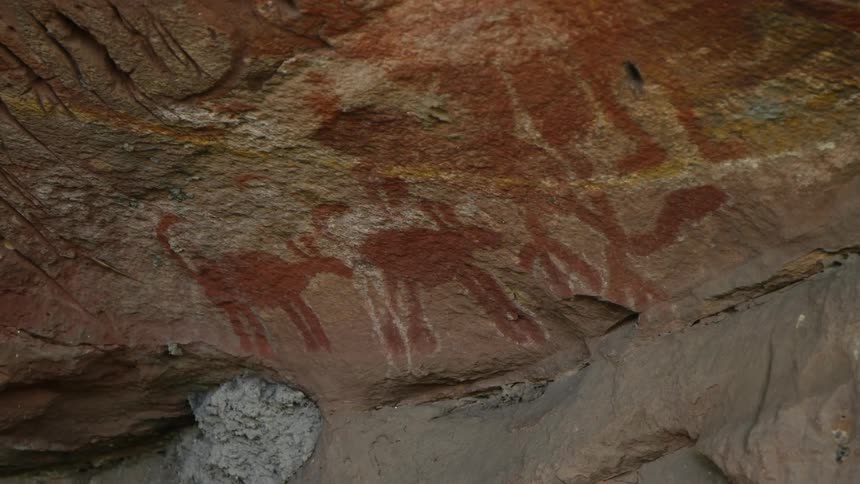 Ancient archeological pictographs on vertical stone surface