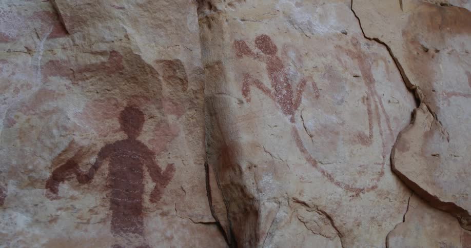 Artwork on a cracked natural stone wall outdoors during the day