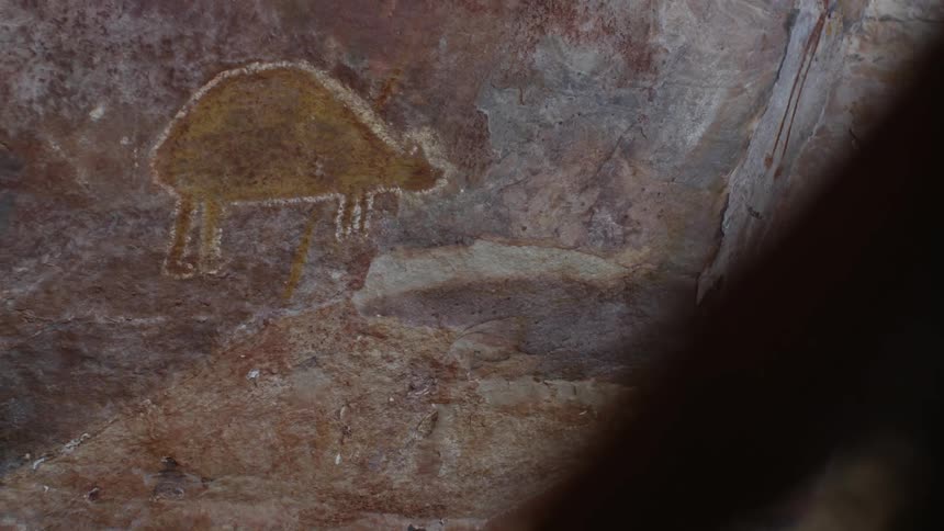 Ancient archeological pictographs on a vertical rock wall