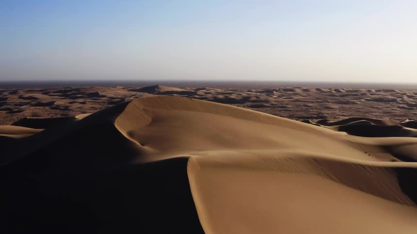 Aerial view of wind blowing the sand in the dunes of a desert
