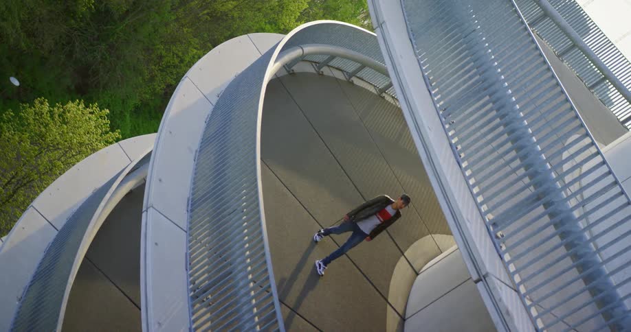 Man carries a camera as he walks on a circular platform