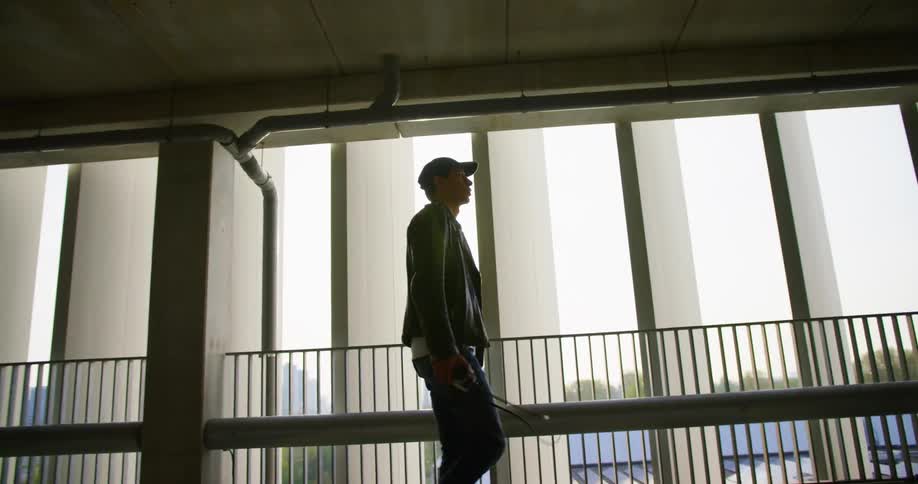 Man carrying a camera walks on a walkway in a tunnel