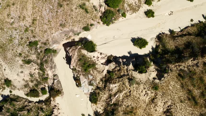 Aerial view of people hiking through a sandy area