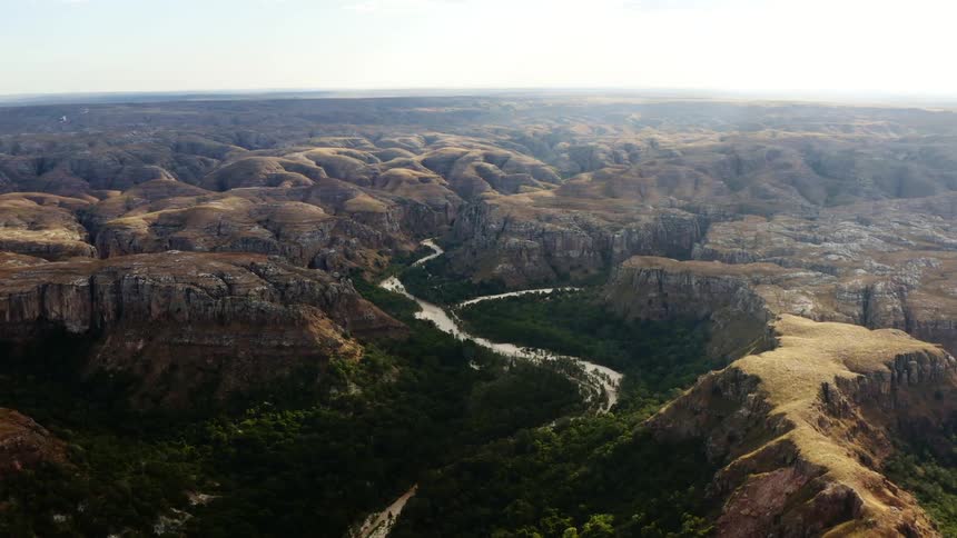 An aerial view of a river running between cliffs and canyons