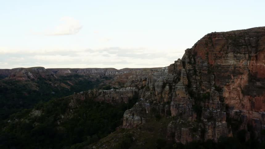 Under a cloudy sky is a chain of rocky canyons that are breathtaking