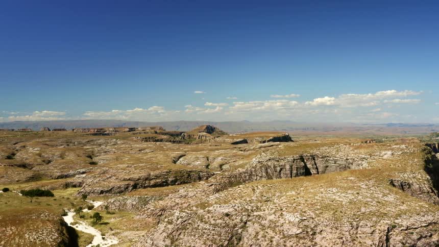 A landscape view of a field with cliffs and grass