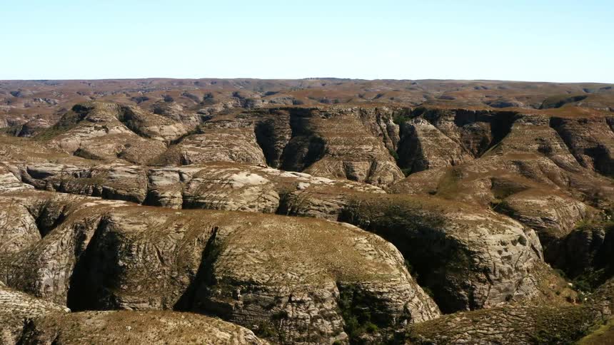 Aerial view of canyons covered in bushes and shrubs in the badlands
