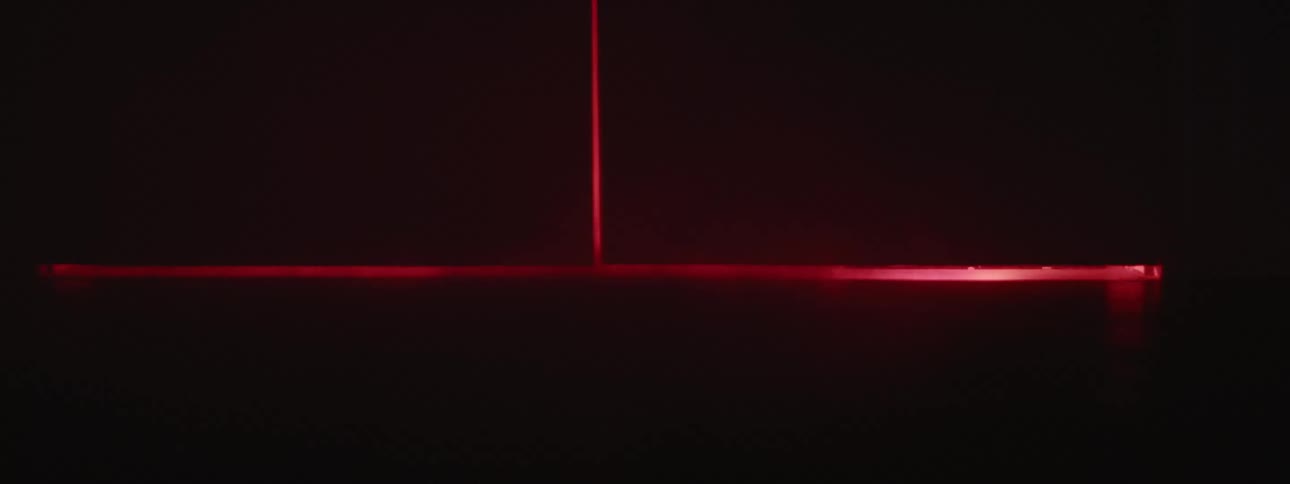 A red light coming from under a door with smoke