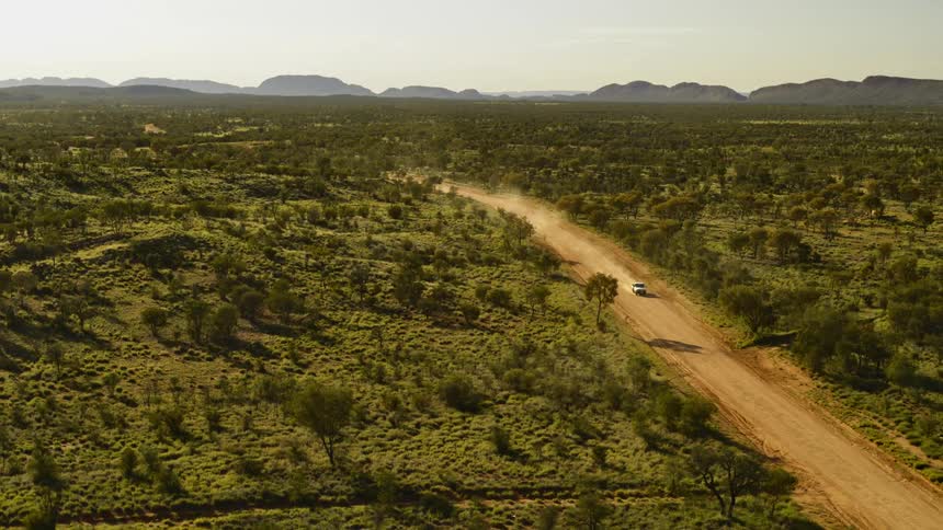 Truck driving along a dirt road in a rural area