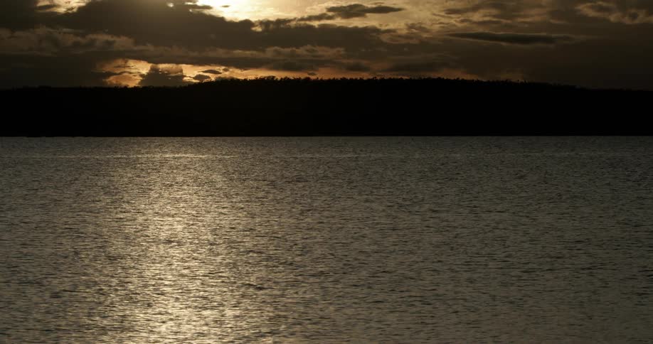 The setting sun shines on the ocean water