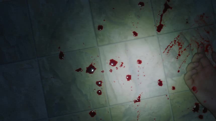 A splattering of blood on a floor leading to a body