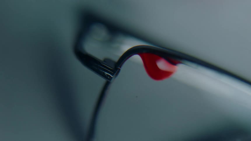 Close up of a drop of red blood in the crystal of glasses