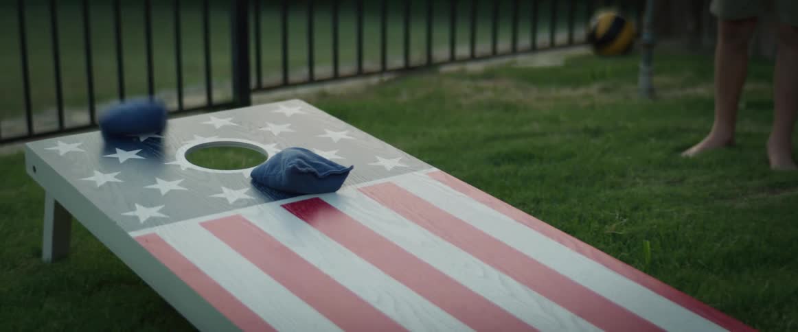 Bean bags being tossed during a game of corn hole