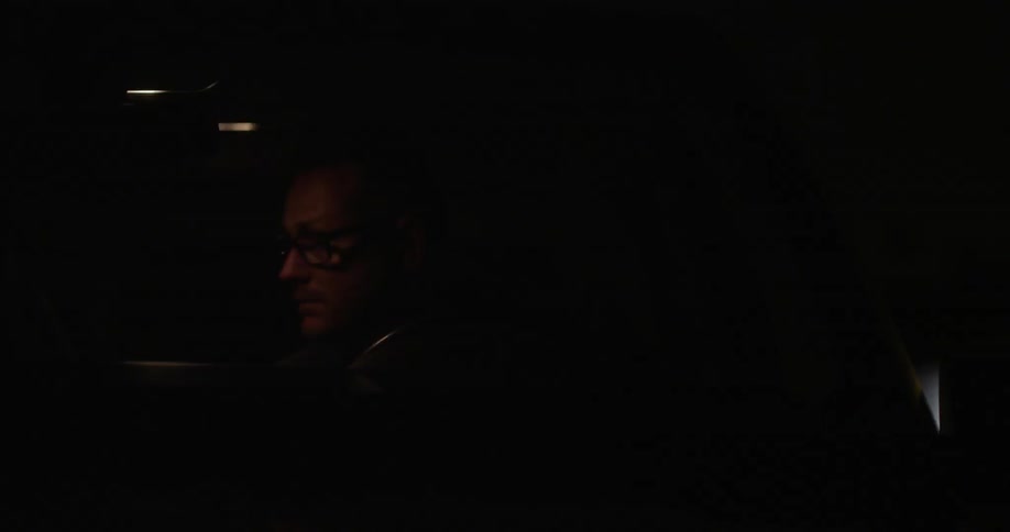 A man sits in his car at night