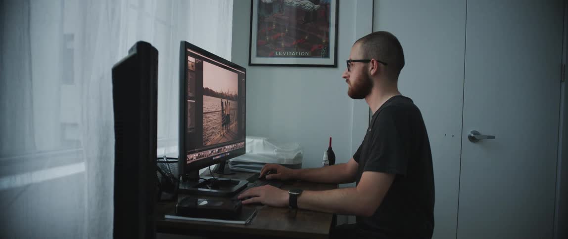 A man sitting at home looks at his computer
