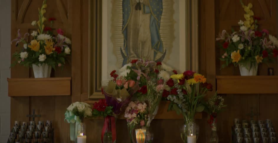 Lit candles and flowers in a church