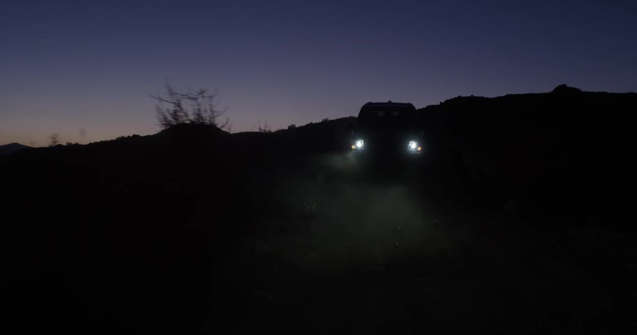 A car drives down a dark road at night