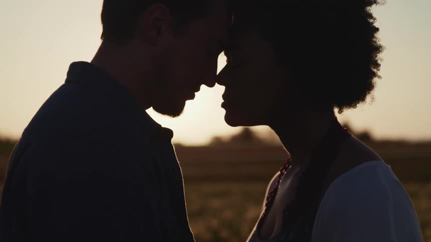 A man and woman stand together at sunrise