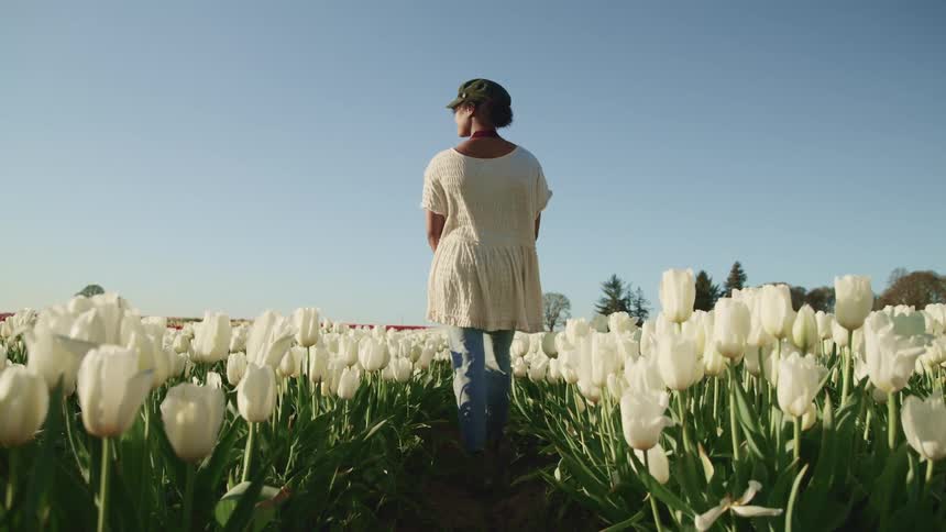 A woman is standing in a flower meadow