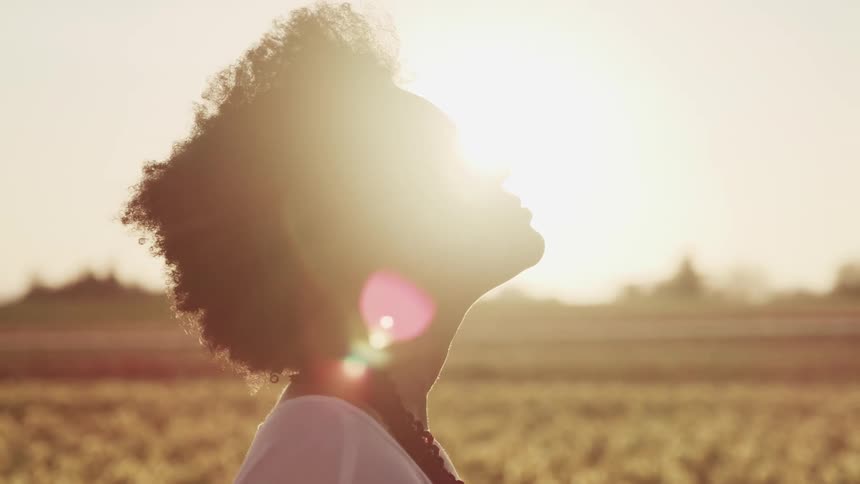 A woman standing in a field looking up