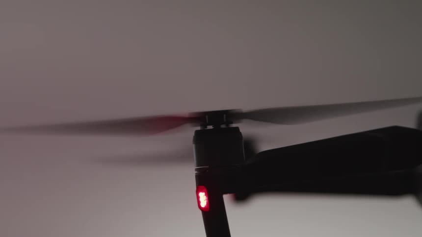 Close up of the spinning rotors of a drone in a dark room