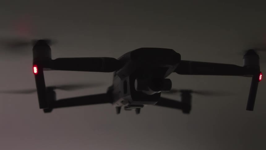 A drone staying in place with its propellers spinning