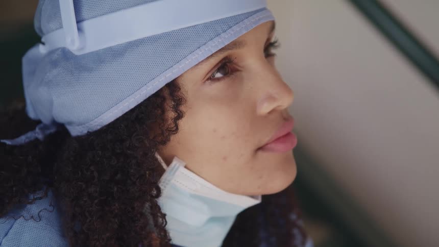 A doctor standing looking at something in the distance
