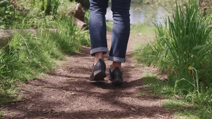 A person walks a long a path towards the water
