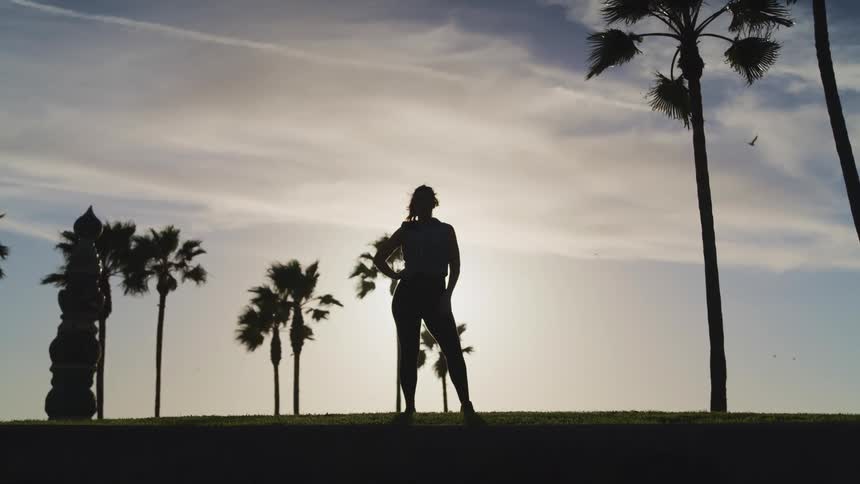 A woman stands and looks out at the landscape