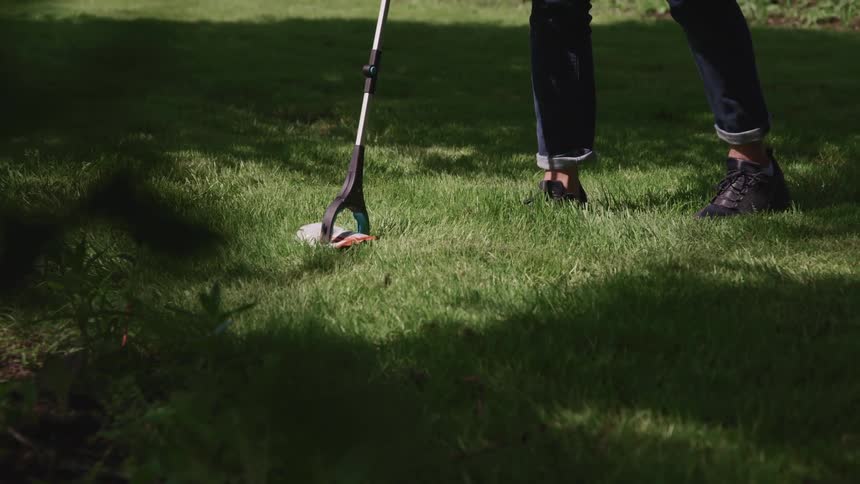 A person is lifting litter with a grabber