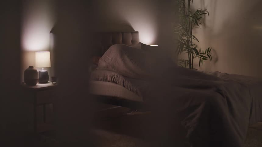 A person is sleeping in the bed under the covers