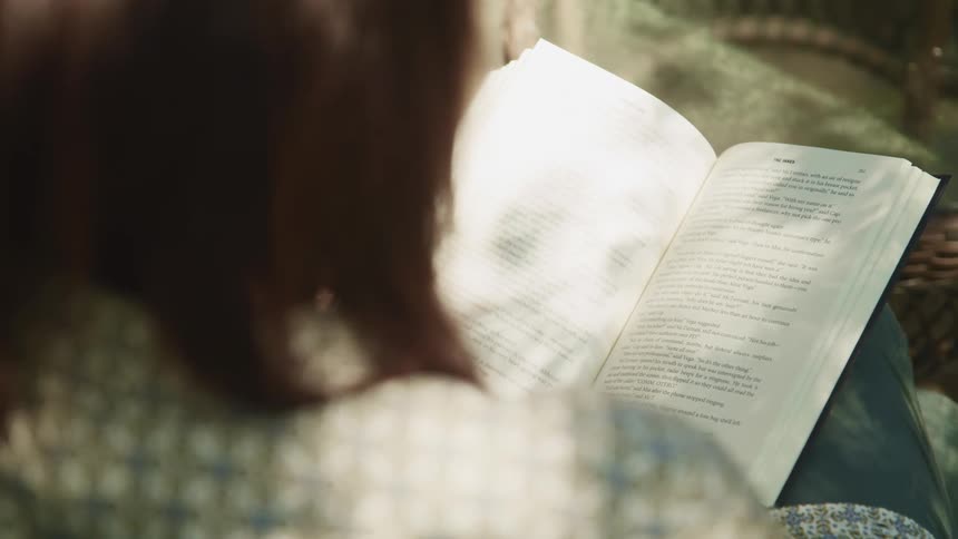 A woman reading a book on her lap