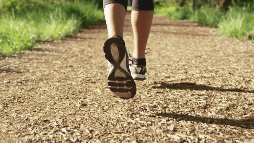 A person is running on a trail through the field