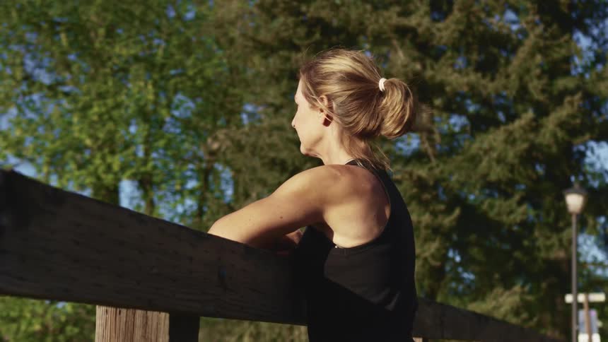 Young woman reclined in the railing of a wooden tree