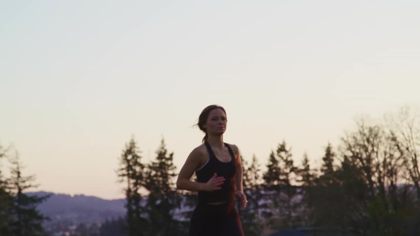 A woman is running outside at sunrise
