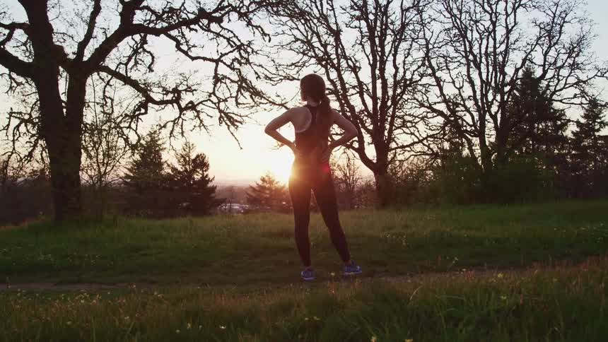 A woman is standing watch the sunrise