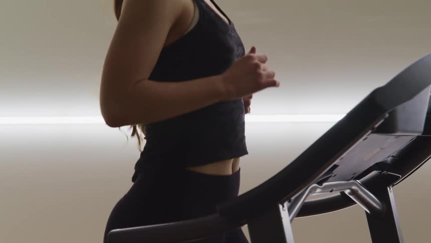 A woman is jogging on a treadmill