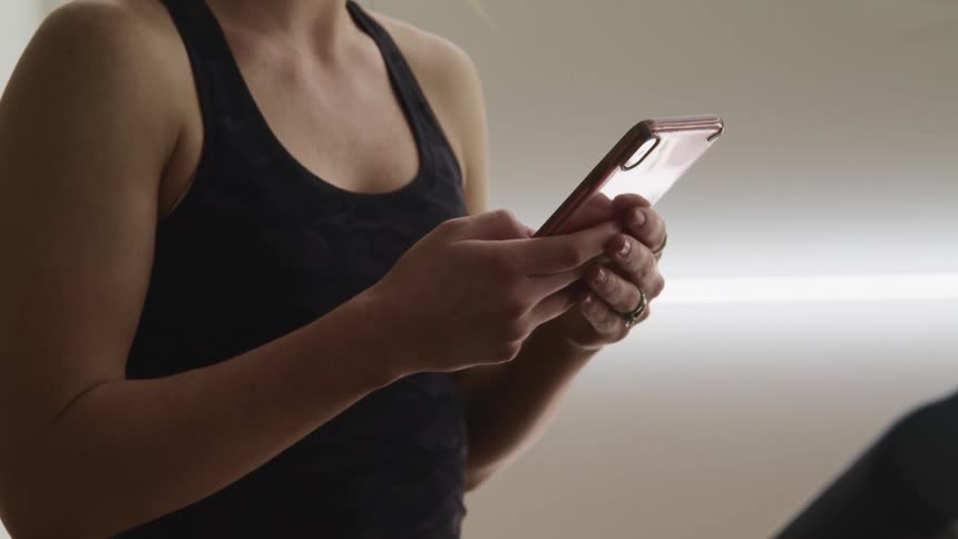 Woman uses a smartphone while using a walking machine