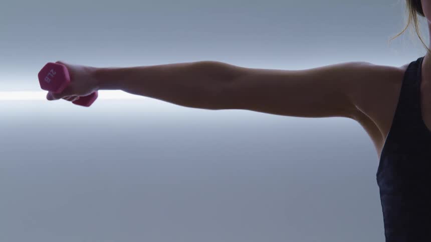 A woman is lifting a small weight