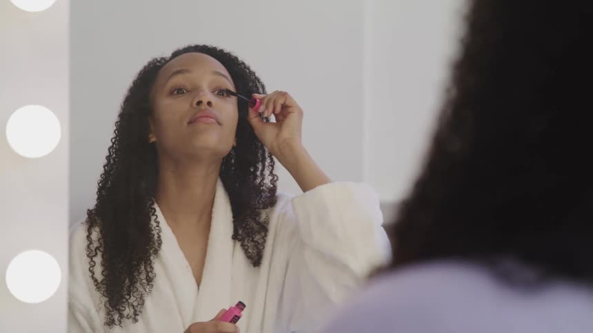 A woman puts make up on at home