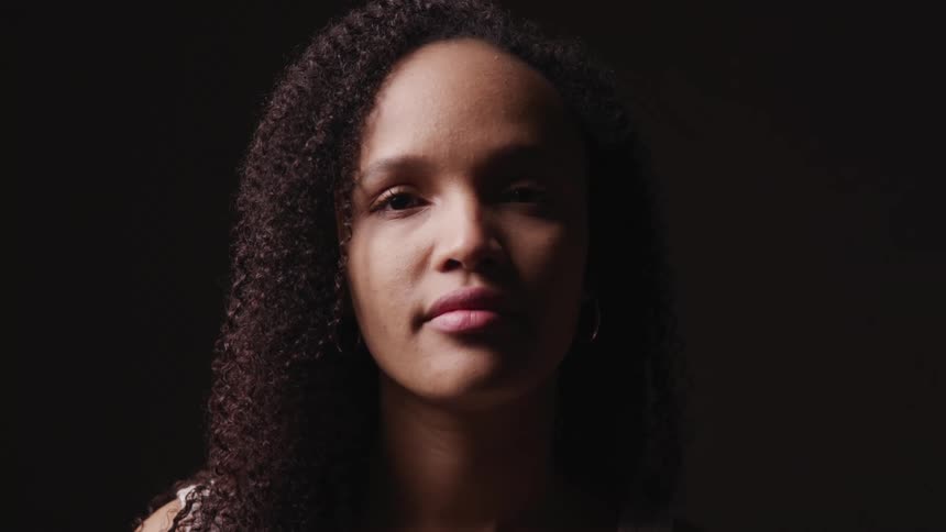 Close up of an african american womans face against a dark black background