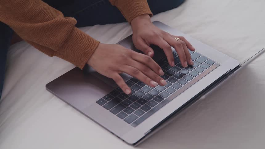 A person is typing on their laptop