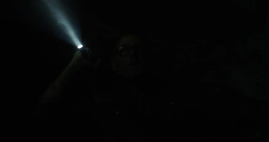 A person is shining a flashlight in a dark area
