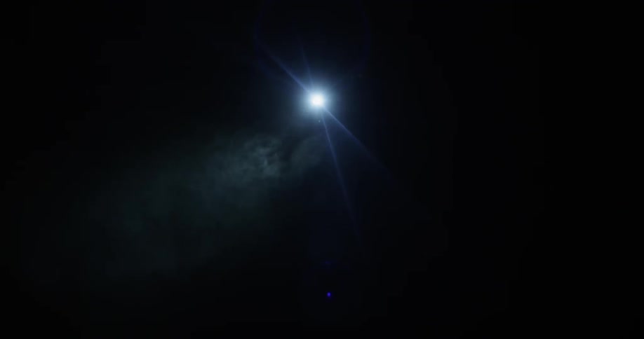 A person using a flashlight in a dark cave